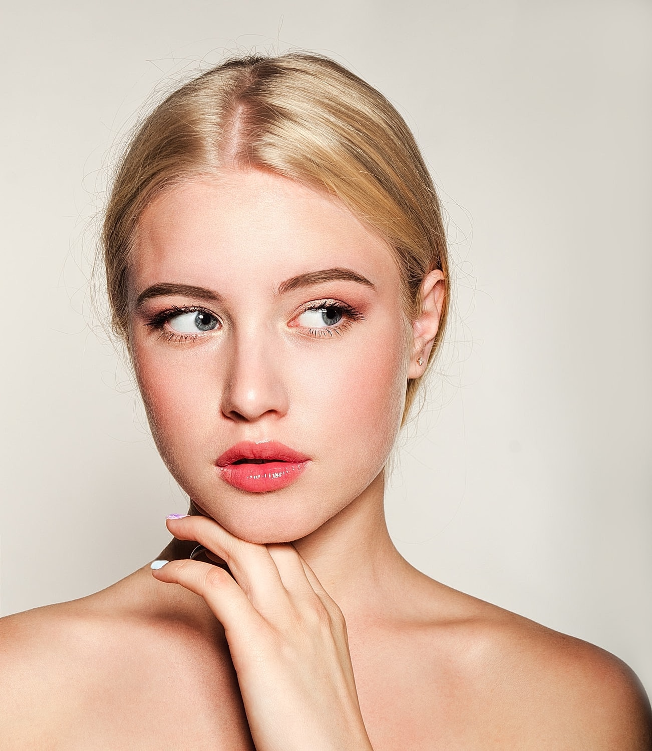 Blonde woman with soft makeup and thoughtful expression
