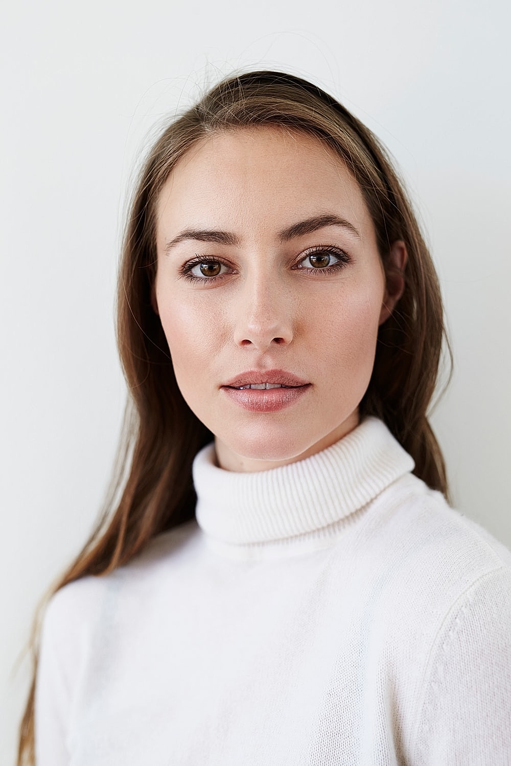Young woman in a white turtleneck sweater.