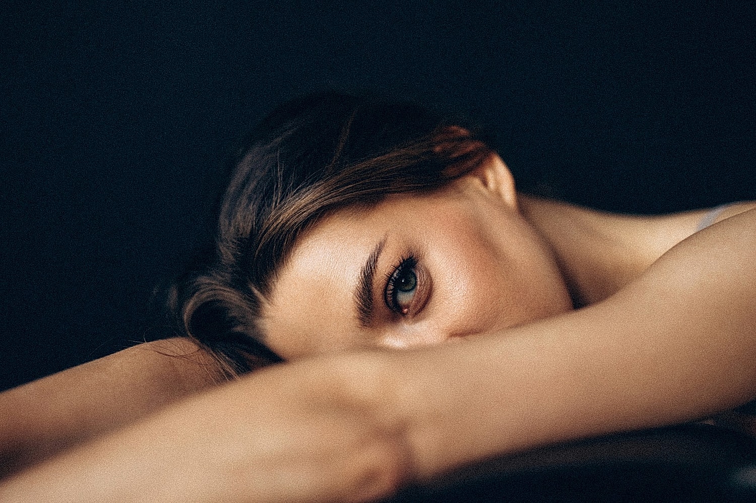 Close-up of a woman's eye and shoulder.