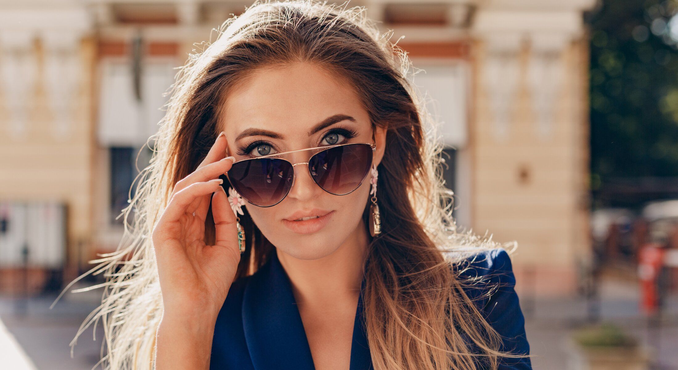 Woman wearing sunglasses, posing confidently outdoors.